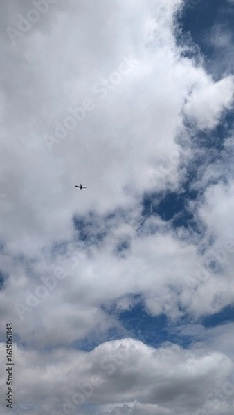 Fototapeta A Helicopter Gracefully Gliding Through a Dramatic, Cloudy and Beautiful Sky Above Us