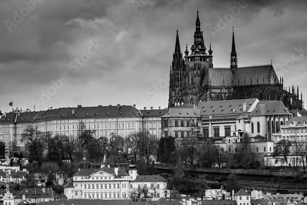 Fototapeta A panoramic view of Prague Castle, captured from the Old Town Hall Tower, showcases red-roofed buildings and the majestic gothic cathedral in Prague, Czech Republic (Czechia), under a dramatic sky.