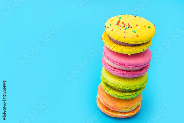 Obraz A few brightly colored stacked macarons on blue background. Mixed of colorful macaroni or pasta cake. Tasty and colorful french macarons. Culinary, cooking concept, styling food. Add your text.