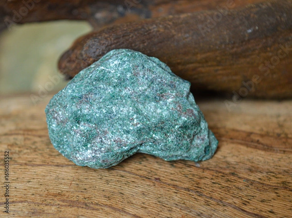 Fototapeta Fuchsita mineral stone on a wood background