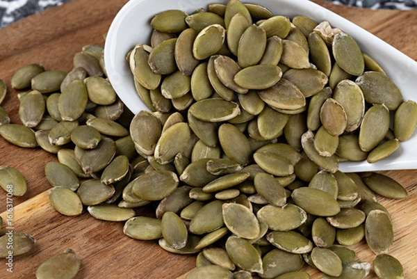 Obraz Pumpkin seeds on wooden board. Selective focus