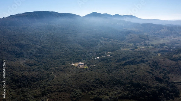 Fototapeta Aerial view of the São José mountain range, which borders the city of Tiradentes, in Minas Gerais, Brazil, on a beautiful dawn with clouds and blue sky.