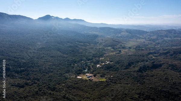 Fototapeta Aerial view of the São José mountain range, which borders the city of Tiradentes, in Minas Gerais, Brazil, on a beautiful dawn with clouds and blue sky.