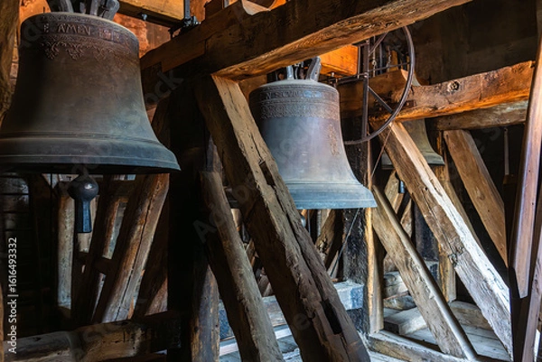 Obraz Old bells from the St. Wenceslas Church hang in a late Gothic wooden belfry – rustically positioned in the tower, flanked by timber and metal bell supports