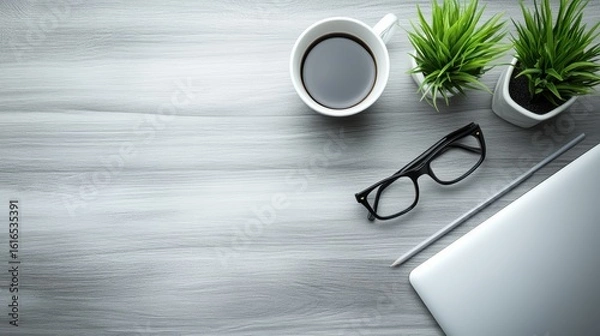 Obraz A clean top-down view of a desk with only a laptop and a cup of tea or coffee