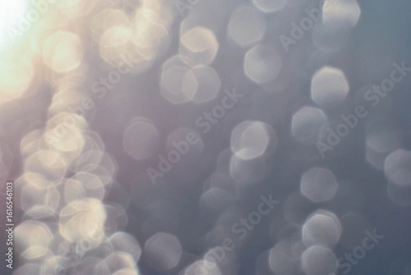 Fototapeta Water droplets scatter golden light, creating a soft, diffused effect.
