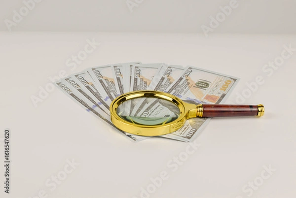 Fototapeta Close-up view of US banknotes under a magnifying glass.