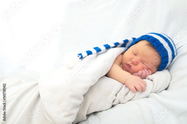 Fototapeta baby portrait with jaundice, sleeping newborn in hat on white blanket, cute child