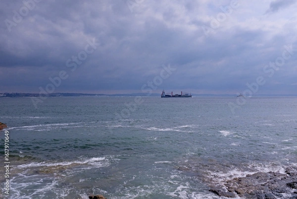 Fototapeta High waves in the ocean and a  big boat seen in the distance