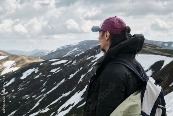 Obraz Hiker with backpack overlooking snow-covered mountain landscape