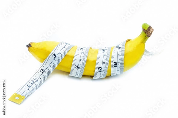 Fototapeta Measuring tape wrapped around a banana, isolated on a white background