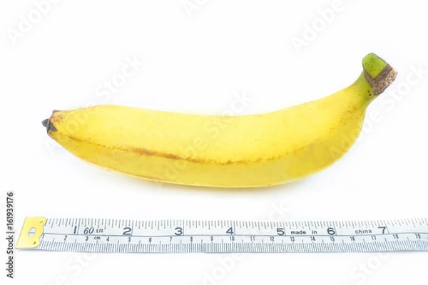 Fototapeta Measuring tape wrapped around a banana, isolated on a white background