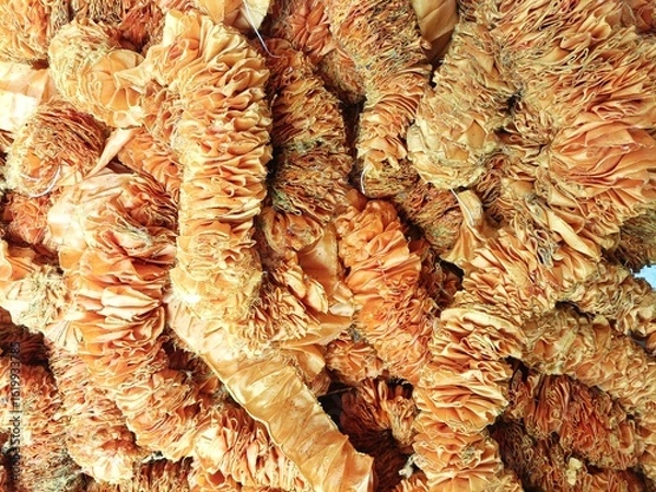 Fototapeta Close-up detail of a pile of tangled orange faded fabric garland with variegated color