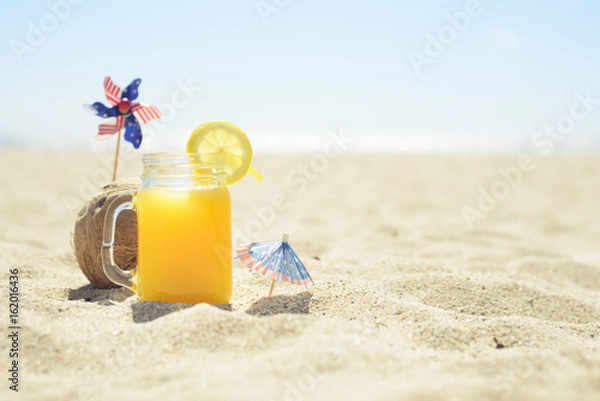 Fototapeta Sunglasses and phone on the beach with people on background