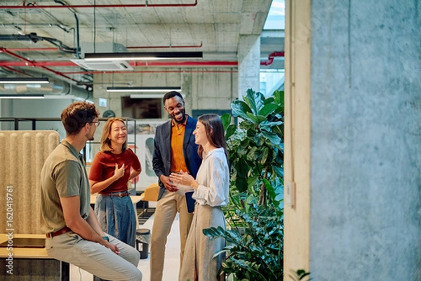 Obraz Multicultural businesspeople talking and smiling during a meeting in a modern office with plants