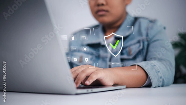 Fototapeta Cyber security concept showing Asian boy using laptop with digital interface, symbolizing online safety, data privacy, and child internet protection.