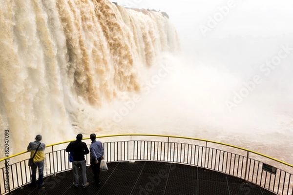 Fototapeta tourists in a platform at iguazu falls veiw from brazil