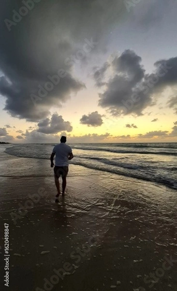 Fototapeta Walking on the beach at sunset