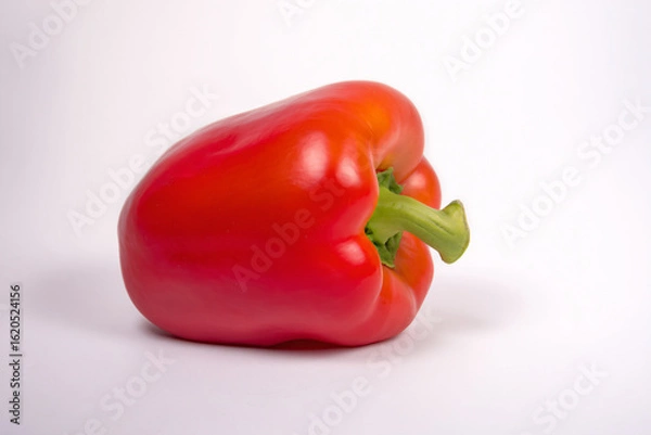 Fototapeta a red pepper with a green stem on a white surface