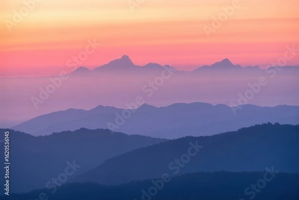 Obraz Serene mountain layers bathed in the soft hues of a vibrant sunrise