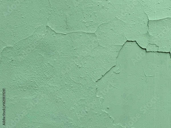 Fototapeta Old green painted wall close up image with cracks and weathered texture background. Rural, vintage, urban, and rustic design backgrounds theme