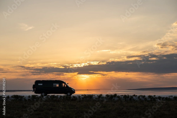 Fototapeta Silhouette of a 4x4 camper with a lake behind it