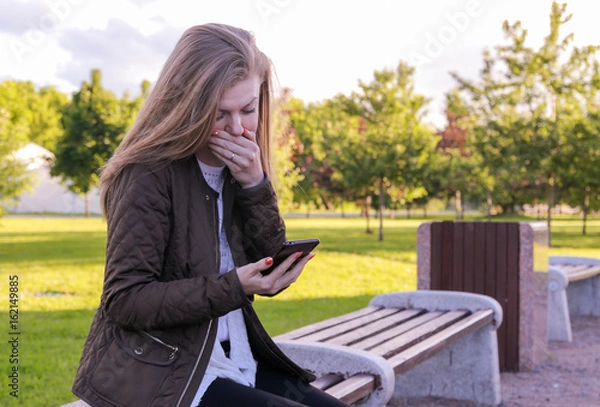 Fototapeta The girl reads a sad text message