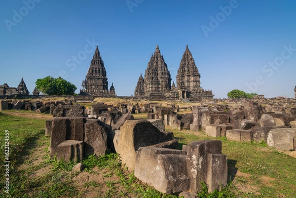Obraz View of Prambanan temple, a UNESCO World Heritage site. Under a brilliant clear blue sky, the massive, intricately carved stone structures rise majestically, located on Klaten, Indonesia.
