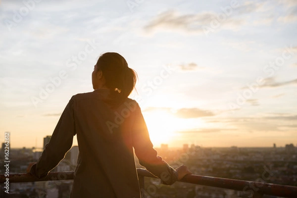 Obraz women see city view when sunset time