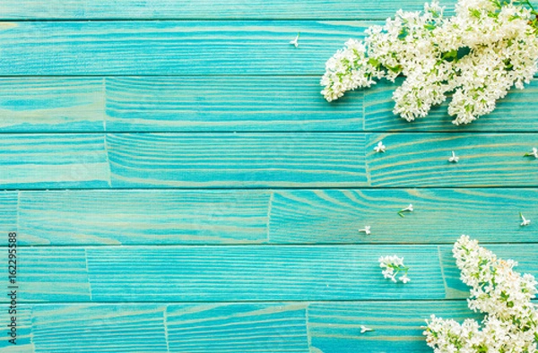 Obraz Flowers background. Lilac flowers on turquoise wooden background. Top view, flat lay, copy space