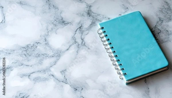 Obraz Light teal notebook on white marble surface