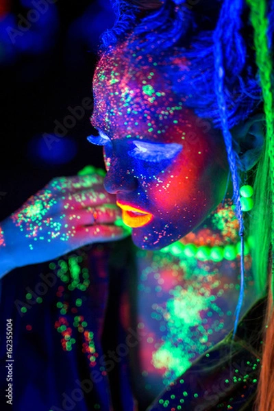 Fototapeta luminous portrait of a girl in the UV rays on white background