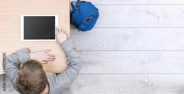 Fototapeta boy in classroom behind tablet pc header image