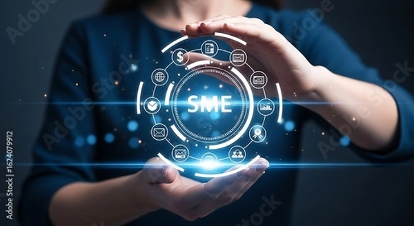 Obraz Hands cupping a glowing blue holographic SME circle surrounded by business and technology icons against a dark background.