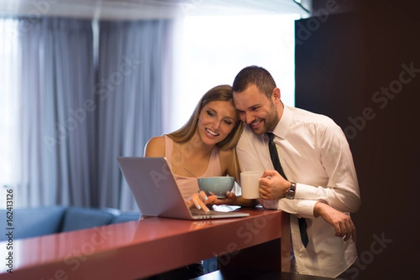 Fototapeta A young couple is preparing for a job and using a laptop
