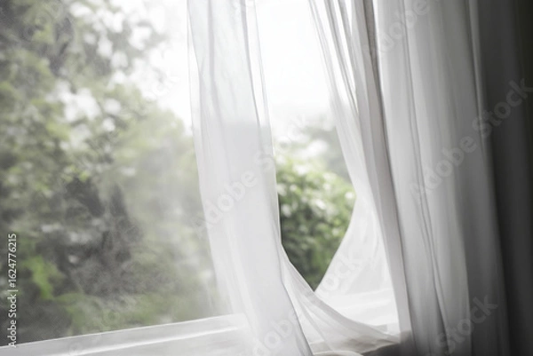 Obraz Soft wind blowing sheer white curtain in open window, blurred greenery outside, sense of refreshing air flow
