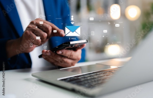 Fototapeta Businessman using mobile phone, laptop open email with sign reminder for unread emails for notification and taps on a new inbox email notification icon, newsletter. Technology digital online network