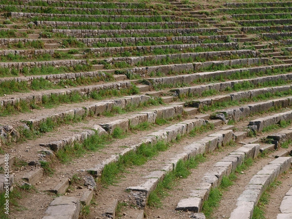 Fototapeta The steps of the ancient amphitheater, overgrown with grass.