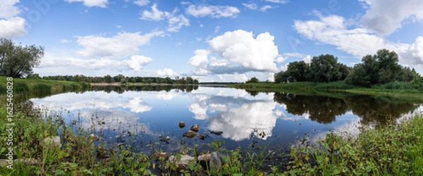 Fototapeta A wide reflection of the floodplain landscape near Wahrenberg: tranquil floodplain waters, reflected sky, and green riverbanks – an idyllic Elbe landscape with a natural atmosphere