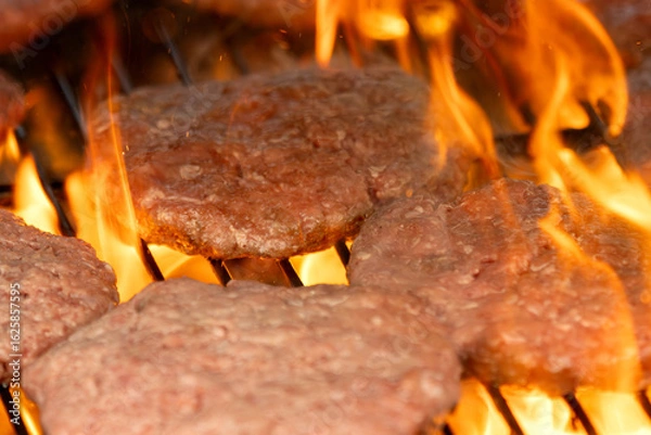 Obraz Raw hamburger patties on a hot grill