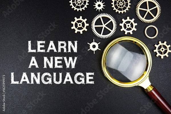 Obraz Learn A New Language text message with magnifying glass on black background