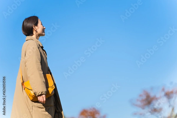 Fototapeta 丘を歩く女性　ライフスタイルイメージ