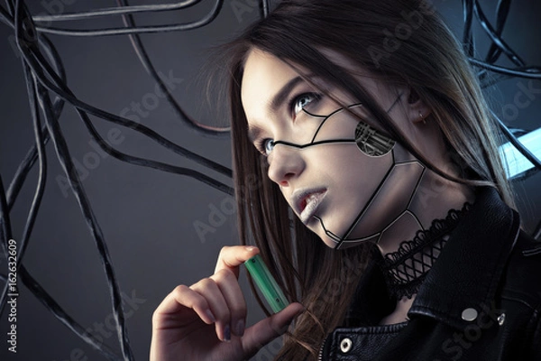 Obraz charming robot girl with cyberpunk style makeup holding battery in hand, concept energy saving