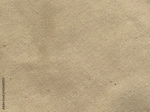 Fototapeta Close-up of light brown shirt fabric texture. Soft, detailed beige cloth surface, natural fibers, perfect for fashion, textile, apparel, background, design, and fabric-related projects