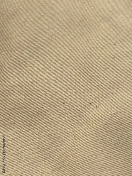 Fototapeta Detailed close-up of brown fabric showing woven texture and fibers. Ideal for fashion, textiles, backgrounds, and design projects needing natural, rustic cloth visuals