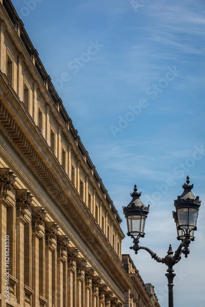 Fototapeta The elegant Stone Facade of the Grand Theatre Building in Bordeaux, France; Close-up with ancient Street Light and blue Sky - Copy Space