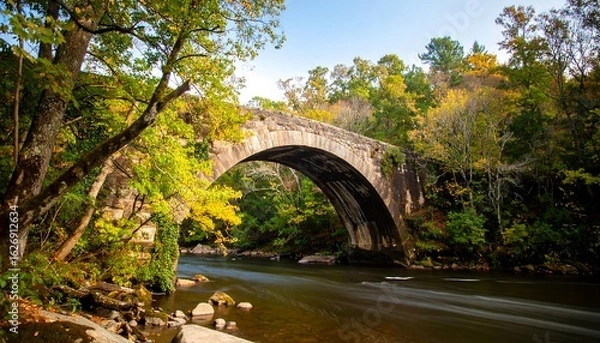 Obraz Autumnal stone arch bridge over a flowing river