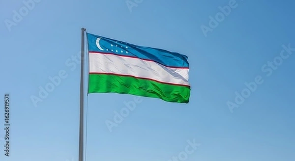 Fototapeta The national flag of Uzbekistan waving proudly on a flagpole against a clear, bright blue sky.