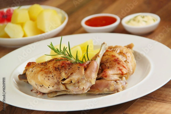 Obraz Roasted rabbit, boiled potatoes and rosemary herb. Close up view.