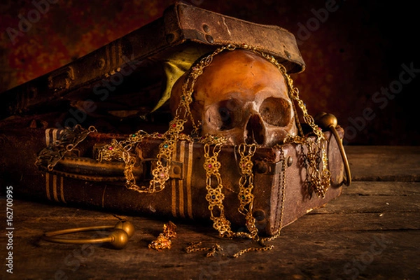 Fototapeta Still life with human skull with old treasure chest and gold, diamond and jewelry on wooden background